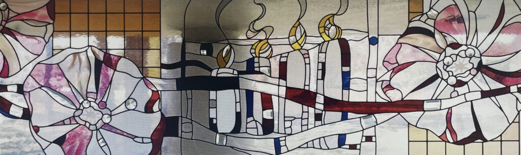 stained glass window of flowers with 4 candles in the middle