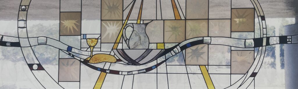 stained glass window depicting bread and wine. 