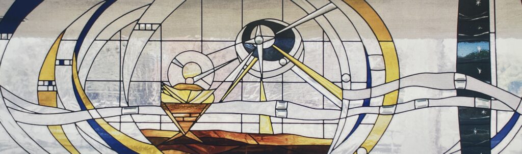 stained glass window of the nativity scene with a baby jesus and a star above him. 