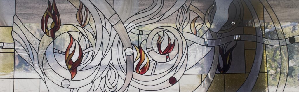stained glass window with image of swirling flames and designs. 