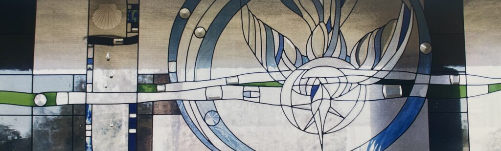 stained glass window of dove diving downward with blues and clears. small clear glass water drops are attached to the surface. 