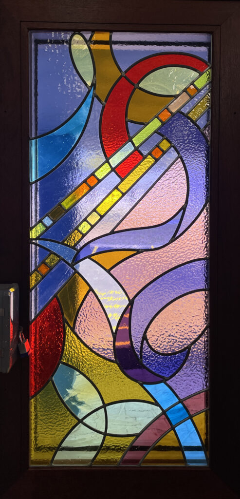 abstract stained glass window with light rays cutting diagonal across the panel. pink, purple, orange color palette. 