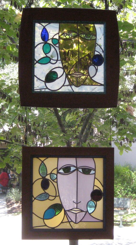 two small square glass panels with an abstract face in each one. 