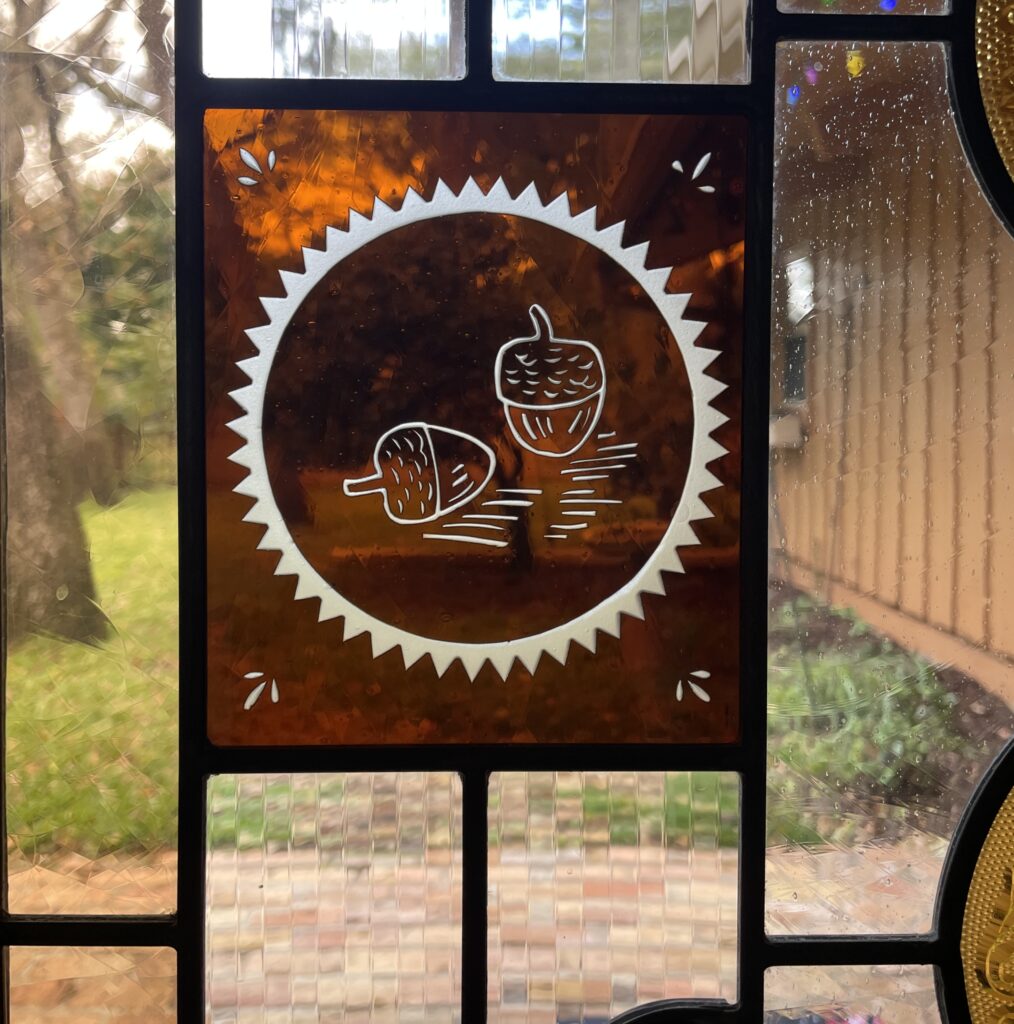 detail of etched acorn into brown glass. 