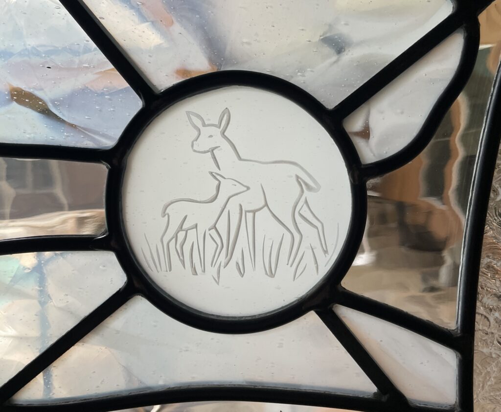 close up detail of etched glass deer.